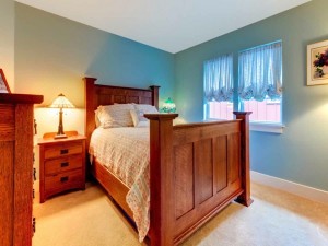 Blue clasic bedroom with large wood bed.
