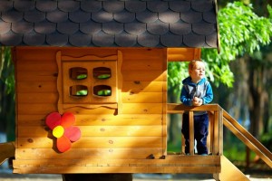 cute baby boy playing in tree house, sunny outdoor