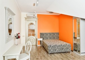 Modern bedroom in bright orange colors with zebra patterned bed
