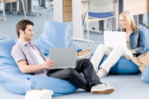 Young students at high-school pointing at laptop