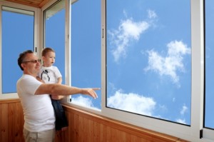 Grandson and grandfather standing on balcony and looking at the