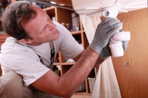 Man fitting the waste on a kitchen sink