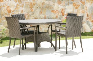 Table and chairs in a tropical garden with a stone wall texture